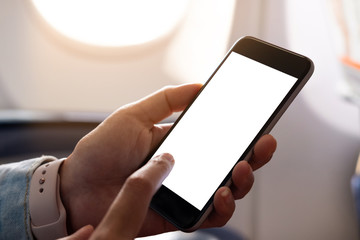 Woman using smart phone with blank screen on board of airplane near window, can be add your texts or others