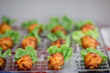 Fried chicken, small pieces fit the mouth and contains green vegetables. Make it look more delicious.