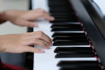 Obraz premium Close up of child hand on piano keys playing