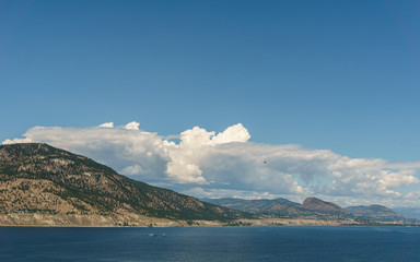 Okanagan lake at summer day with clouds on the sky.