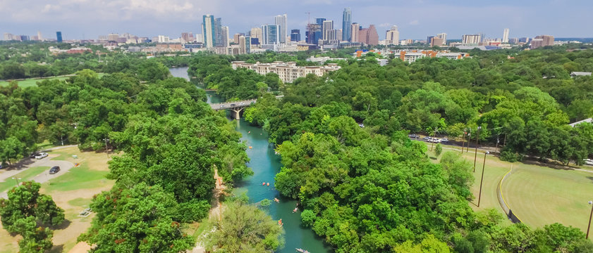 Panorama aerial view Downtown from Barton Creek in Greenbelt at Zilker Metropolitan Park south Austin with summer blue cloud sky. Located at eastern edge of Hill Country, is the state capital of Texas