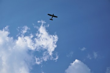Blue sky and white clouds with silhouette of airplane flying, Summer in GA USA.