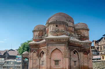 Fototapeta na wymiar Graves surround the Tomb of Budshah, a popular tourist attraction in Srinagar, Kashmir, India.