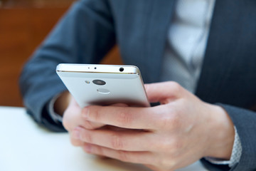 Woman business holding smart phone with blurred background.