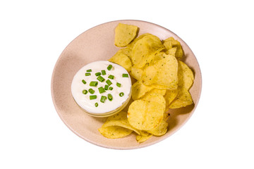 Ceramic plate with potato chips and glass bowl with sour cream isolated on a white background
