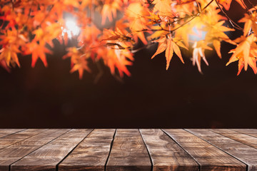 Empty wood table top and blurred autumn tree and red leaf background - can used for display or montage your products.