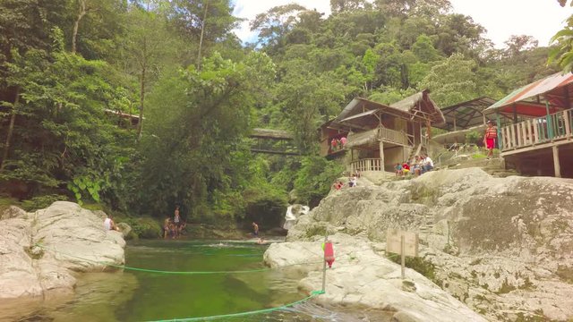 Experience the beauty of Tena Laguna Azul in Ecuadorian Amazon jungle as an unknown group of people enjoy a natural balneary setting on April 14,2018.