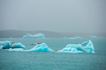 Summer time , Group of travellers take a boat to see the floating ice in the ocean icebergs in Jokulsarlon glacier lagoon, Iceland