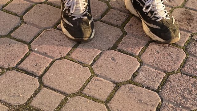 in the city, on the sidewalk, a passer man stops and throws a cigarette butt on the road, close up