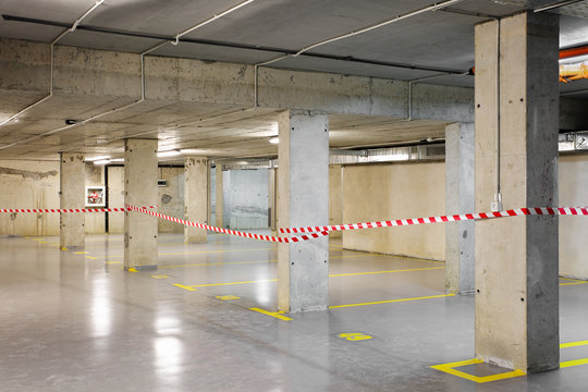 Renewed underground car parking with yellow lot marking and warning tape