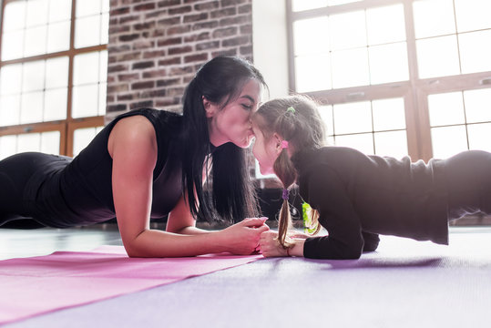 Mother And Daughter Working Out Together Doing Plank Exercise