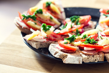 Delicious healthy homemade sandwiches with vegetables and cold cuts on the plate. Shallow depth of focus.