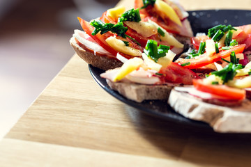 Delicious healthy homemade sandwiches with vegetables and cold cuts on the plate. Shallow depth of focus.
