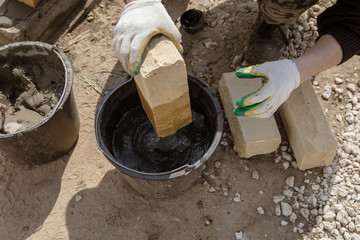 The worker lays bricks on the construction site