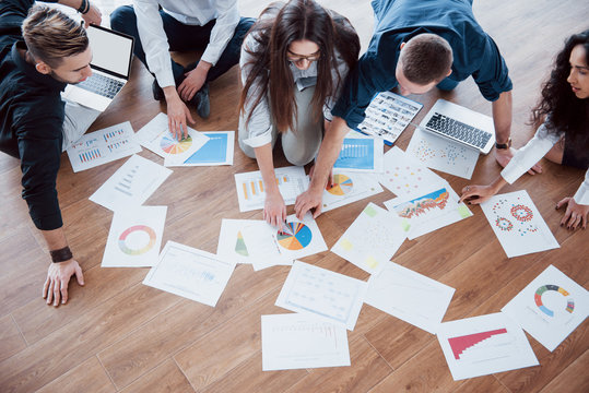 Planning Strategy Together. Business Team Looking At Papers On Floor With Manager Pointing To One Idea. Cooperation Corporate Achievement. Planning Design Draw. Teamwork Concept