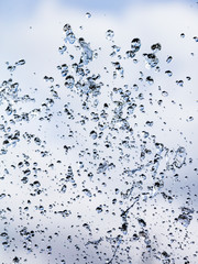 Splashing water with drops on the sky background