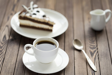Souffle cake with chocolate sauce and coffee, on a wooden table.