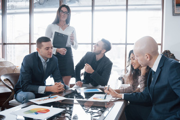 Young team of coworkers making great business discussion in modern coworking office. Teamwork people concept