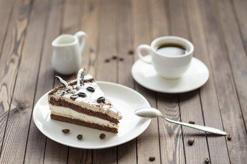 Souffle cake with chocolate sauce and coffee, on a wooden table.