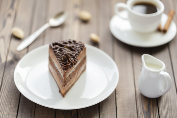 Dessert souffle with chocolate sauce and nuts on a white plate, on a wooden table.