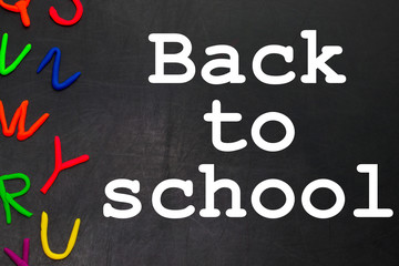 Obraz premium Black chalkboard with colorful letters, concept for education with copy space. Back to school concept