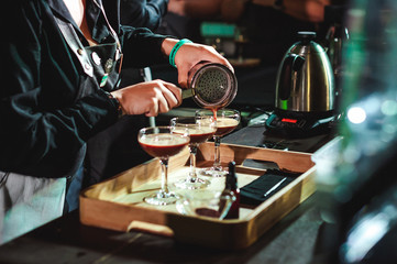 championship among coffee houses, members of teams show barista's skill, prepare drinks, teamwork. pours drink into glasses