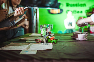 business woman makes notes on a sheet in a notebook, at a restaurant art contest, at a championship among coffee shops, team members demonstrate barista skills, prepare drinks, work in a team.
