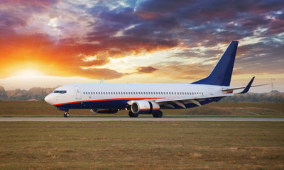 Fototapeta na wymiar Landing airplane in Airport at sunset