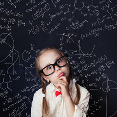 Thinking mathematics student on school blackboard background with chalk hand drawings science formula pattern. Kids mathematics education concept.