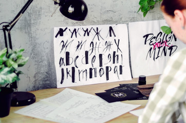 Calligraphic drawings with watercolor on the calligrapher's desktop. Tools and works of the artist.