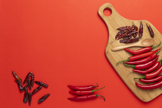 Groups of red chilli peppers and dried asian hot capsicum on the wooden chopping