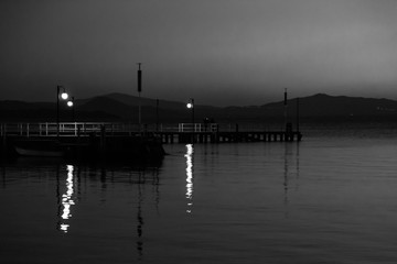 Fototapeta premium Some people on a pier at Trasimeno lake (Umbria, Italy) at dusk