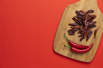 Groups of red chilli peppers and dried chinese hot capsicum on the wooden chopping board