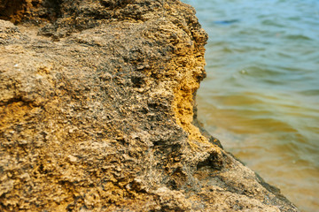 beautiful sea landscape, closeup of stone on the beach, sea coast with high hills, wild nature