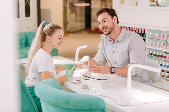 Metrosexual Man. Metrosexual Man Looking At His Lovely Blonde-haired Nail Master While Sitting In Beauty Salon