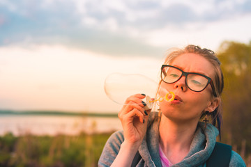 Girl blowing bubbles near the lake