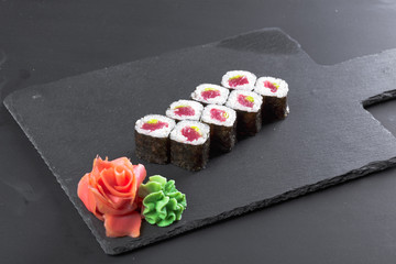 Japanese restaurant, sushi roll on black slate plate.