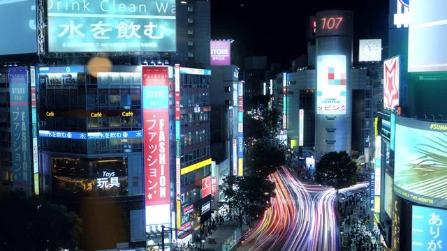 High Angle Time Lapse Shot of Tokyo, Big City Center With Skyscrapers, Glowing Advertising Billboards, Heavy Traffic and Crowds of People at Night.