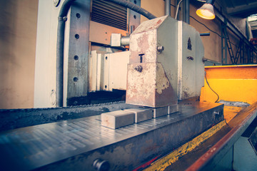 A grinding wheel produces metal scrap on the machine.