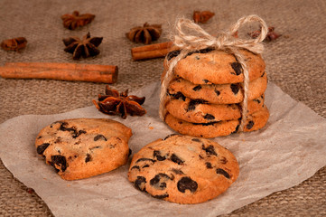 Obraz na płótnie Canvas Sweet cookies with chocolate, cinnamon and milk. Set-up on wood background
