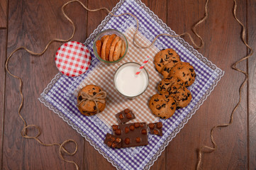 Sweet cookies with chocolate, cinnamon and milk. Set-up on wood background