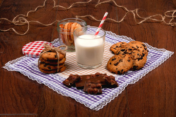Sweet cookies with chocolate, cinnamon and milk. Set-up on wood background