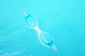 Swimming goggles floating on the water
