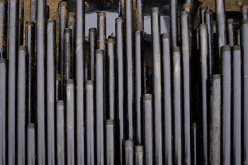 Obraz premium Oil Drill pipe. Rusty drill pipes were drilled in the well section. Downhole drilling rig. Laying the pipe on the deck. View of the shell of drill pipes laid in courtyard of the oil and gas warehouse.