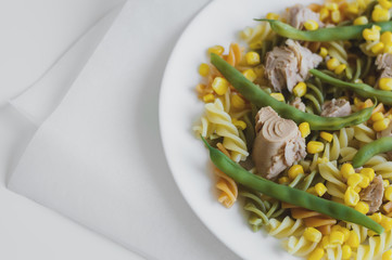 Serving of fresh homemade fusilli pasta with tuna fish, green beans and corn. Healthy lunch. Balanced meal