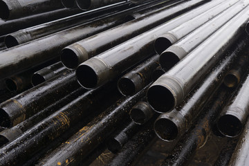 Oil Drill pipe. Rusty drill pipes were drilled in the well section. Downhole drilling rig. Laying the pipe on the deck. View of the shell of drill pipes laid in courtyard of the oil and gas warehouse.