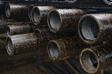 Oil Drill pipe. Rusty drill pipes were drilled in the well section. Downhole drilling rig. Laying the pipe on the deck. View of the shell of drill pipes laid in courtyard of the oil and gas warehouse.