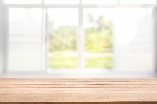 Blur background of white window glass and green view from garden with epty of wood table.