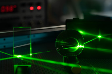Green laser on optical table in a quantum optics lab.