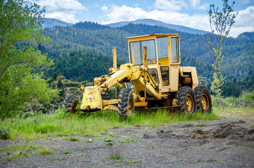Obraz premium Old grader on mountainous road construction